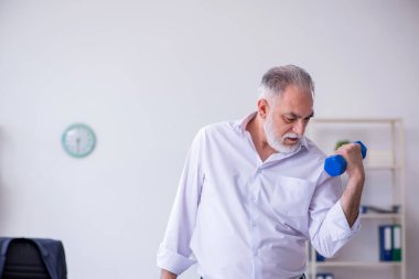 Mola sırasında fiziksel egzersiz yapan yaşlı bir erkek.