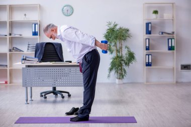 Mola sırasında fiziksel egzersiz yapan yaşlı bir erkek.