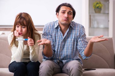 Evde beklenmedik hamilelik konsepti olan genç bir çift var.