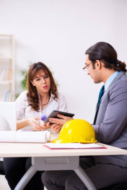Genç işadamı ve bayan mimar yeni projeyi tartışıyor