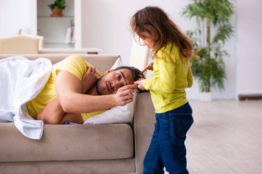 Küçük kız hasta babasına bakıyor.