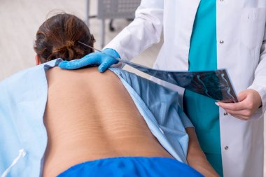 Genç sırtı yaralı bir adam, kadın doktor masörünü ziyaret ediyor.