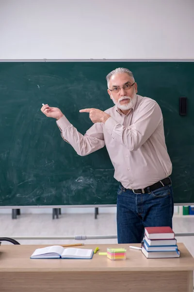 Velho professor sentado na sala de aula — Fotografia de Stock