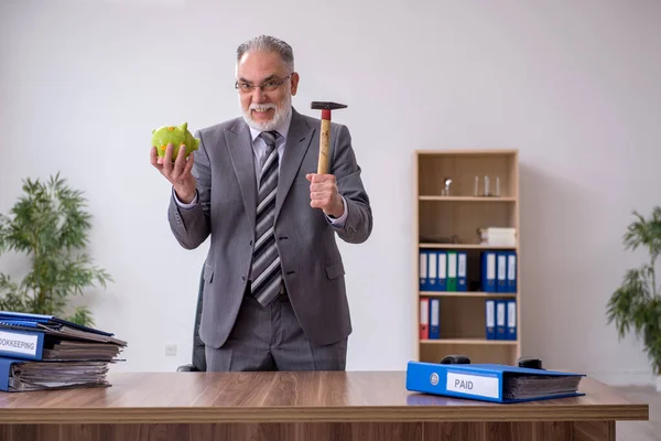 Velho empregado masculino segurando martelo no conceito de planejamento orçamentário — Fotografia de Stock