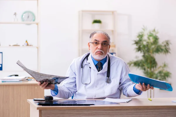 늙은 남성 방사선 전문의가 병원에서 일하고 있다 — 스톡 사진