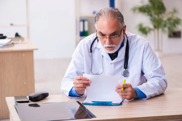 Velho médico do sexo masculino trabalhando na clínica — Fotografia de Stock