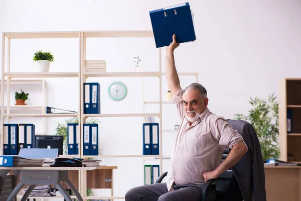 Vecchio dipendente maschio che fa esercizi fisici sul posto di lavoro — Foto Stock