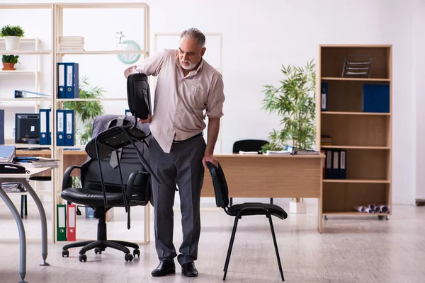 Viejo empleado haciendo ejercicios físicos en el lugar de trabajo — Foto de Stock