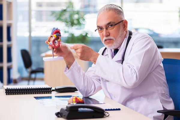 Gammal manlig läkare kardiolog arbetar på kliniken — Stockfoto