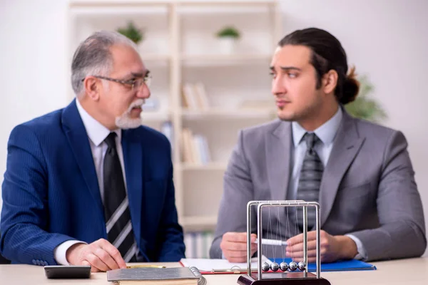 Twee zakenmannen en meditatie ballen op tafel — Stockfoto