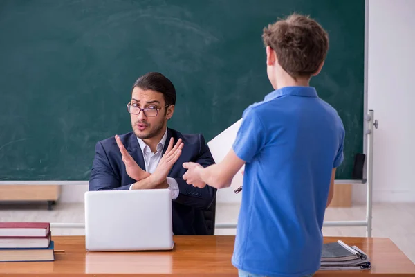 Young male teacher and schoolboy in the classroom — Stock Photo, Image