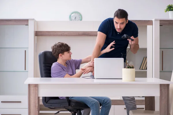 Νεαρός πατέρας και μαθητής παίζουν παιχνίδια στον υπολογιστή στο σπίτι — Φωτογραφία Αρχείου