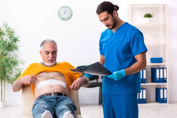 Alt mann besuch jung männlich doktor — Stockfoto