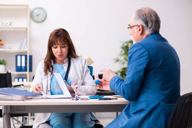 Yaşlı işadamı genç bayan doktoru ziyaret ediyor