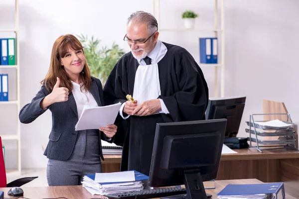 Oude mannelijke rechter en zijn jonge secretaresse op kantoor — Stockfoto