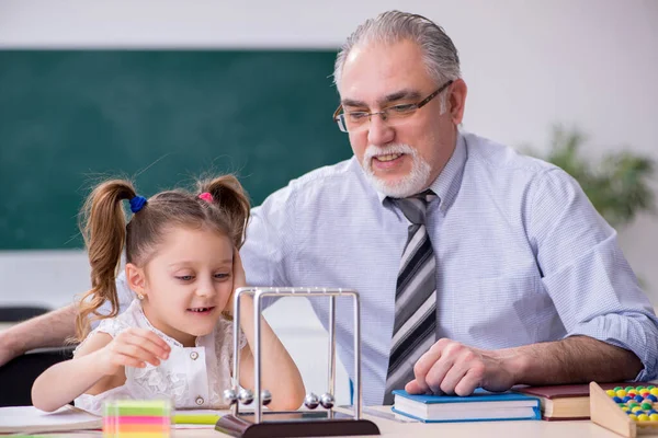 Old teacher and schoolgirl in the school — Stock Photo, Image