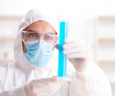 Laboratuvarda kimyasallar üzerinde çalışan genç bir kimyager.