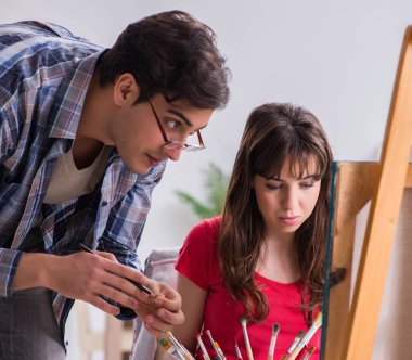 Stüdyoda resim sınıfında sanatçı koçluğu yapan bir öğrenci.