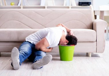 Midesi bulanan ve kusan bir adam.