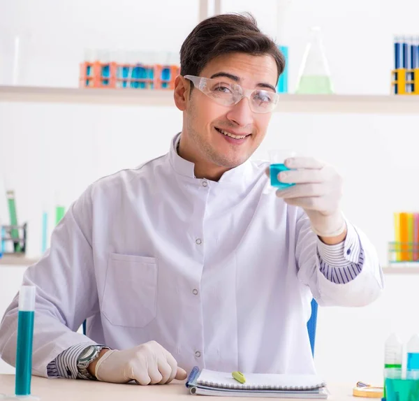 Jovem estudante de química que trabalha em laboratório em produtos químicos — Fotografia de Stock