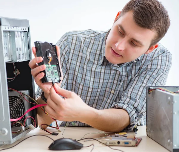 Young technician repairing computer in workshop — Stock Photo, Image