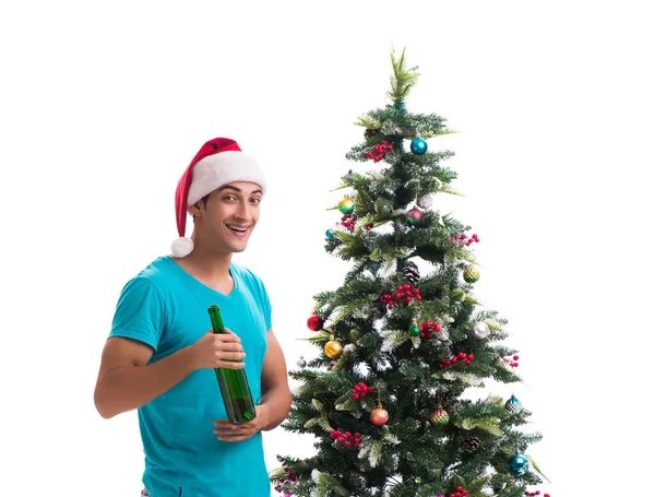 Genç adam beyaz üzerine izole edilmiş noel ağacını süslüyor.