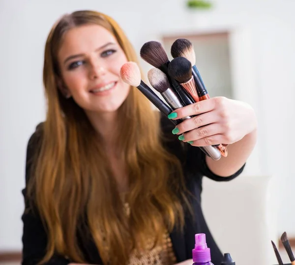 Mujer joven aplicando maquillaje preparándose para la fiesta — Foto de Stock