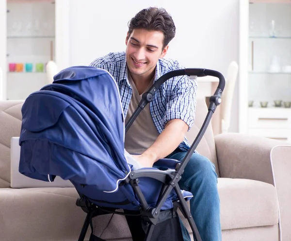 Padre joven cuidando al bebé recién nacido en casa — Foto de Stock