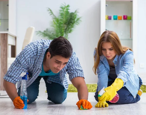 Jovem família limpando a casa — Fotografia de Stock