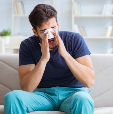 Genç adam estetik cerrahi burnundan sonra evde iyileşiyor.