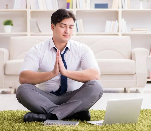 İş adamı ofiste yerde oturuyor.