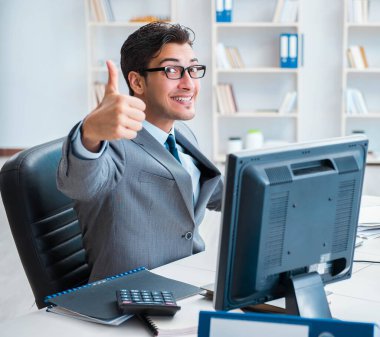 Birçok ekranın önünde oturan bir iş adamı