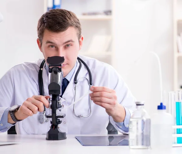 Чоловік лікар дивиться на лабораторні результати в лікарні — стокове фото