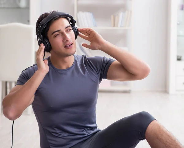 Homem fazendo esportes em casa e ouvindo música — Fotografia de Stock