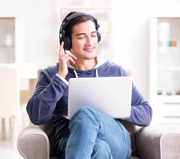 Jonge knappe man die naar muziek luistert met koptelefoon — Stockfoto