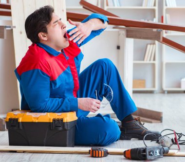 Genç marangoz ahşap kalaslarla çalışmaya ara veriyor.