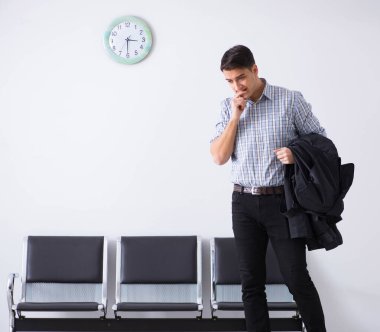 Adam sabırsızlıkla lobide bekliyor.