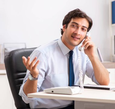 Genç çağrı merkezi operatörü telefonda konuşuyor.