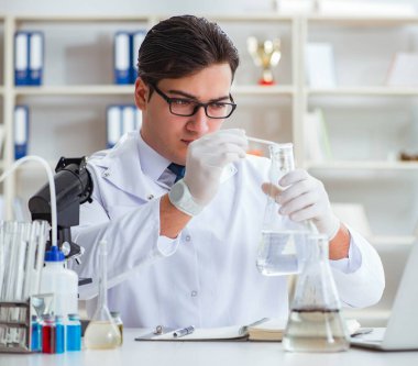 Genç araştırmacı bilim adamı bir su testi kirliliği araştırması yapıyor.