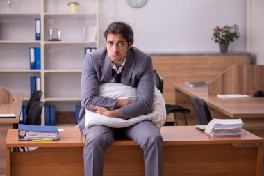 İş yerinde uyuyan genç bir erkek işçi.