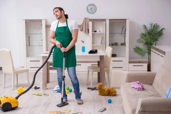 Jovem empreiteiro masculino limpando o apartamento após a festa das crianças — Fotografia de Stock