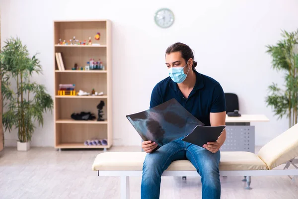 Joven esperando al médico durante la pandemia en el hospital — Foto de Stock