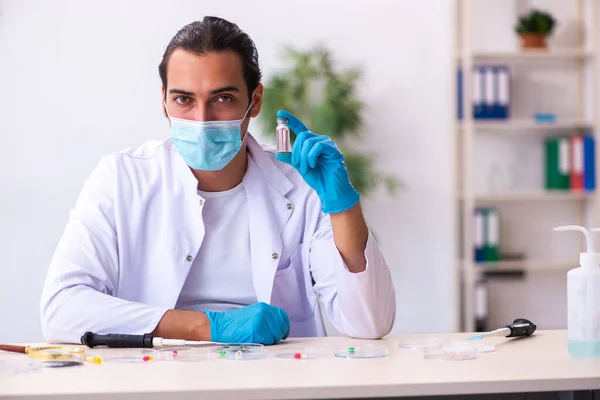 Giovane chimico maschile che lavora in laboratorio durante la pandemia — Foto Stock