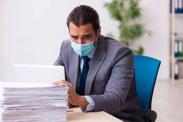 Ung manlig anställd bär mask under pandemi — Stockfoto