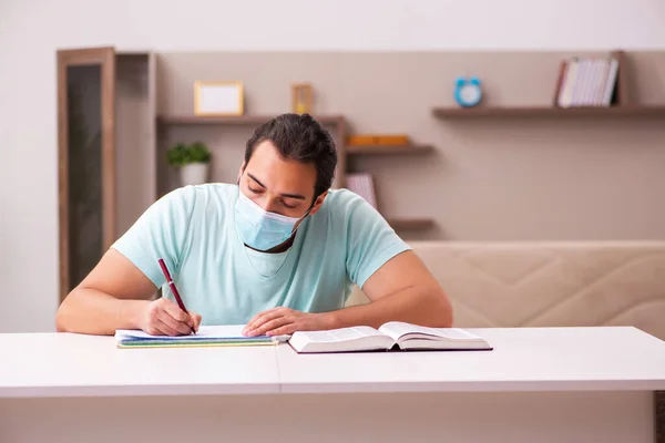 Giovane studente maschio che studia a casa durante la pandemia — Foto Stock