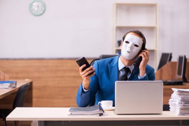 Ofiste maske takan genç bir erkek.