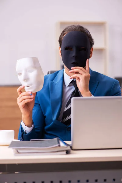 Joven empleado con máscaras en la oficina —  Fotos de Stock