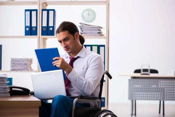 Junge männliche Angestellte nach Unfall im Rollstuhl am Arbeitsplatz — Stockfoto