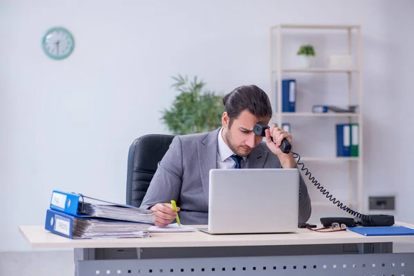 Young male employee unhappy with excessive work in the office — Stock Photo, Image