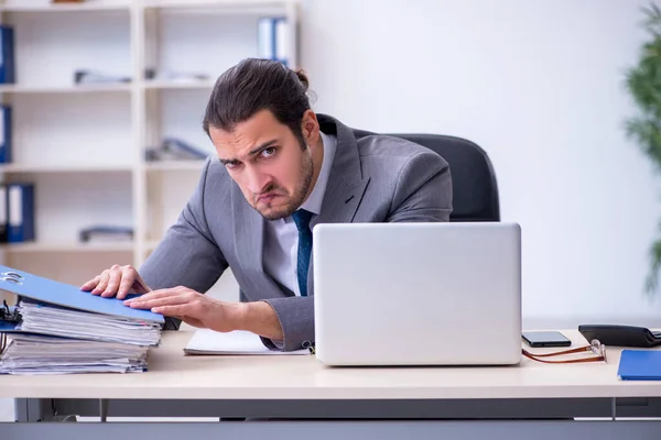 Joven empleado masculino descontento con el trabajo excesivo en la oficina —  Fotos de Stock